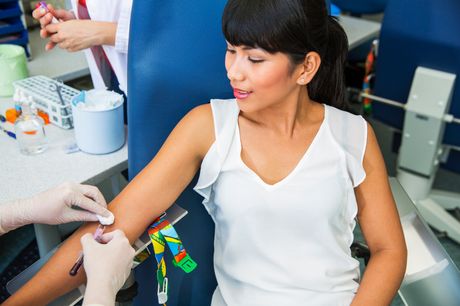 Woman sitting in chair, donating blood. 