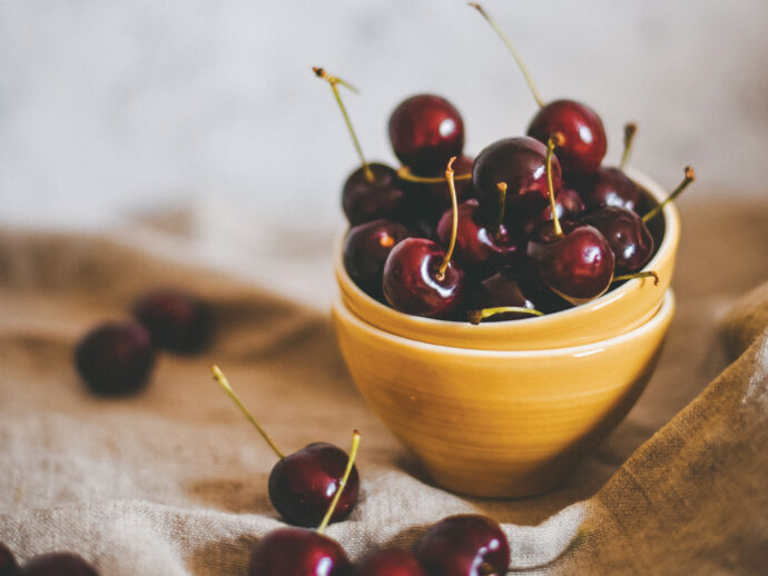 a bowl of cherries sitting on a cloth as they prepare to improve the mental health of someone ageing