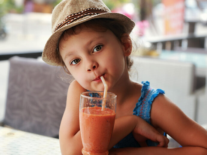resilient child drinks from orange smoothie after being raised properly